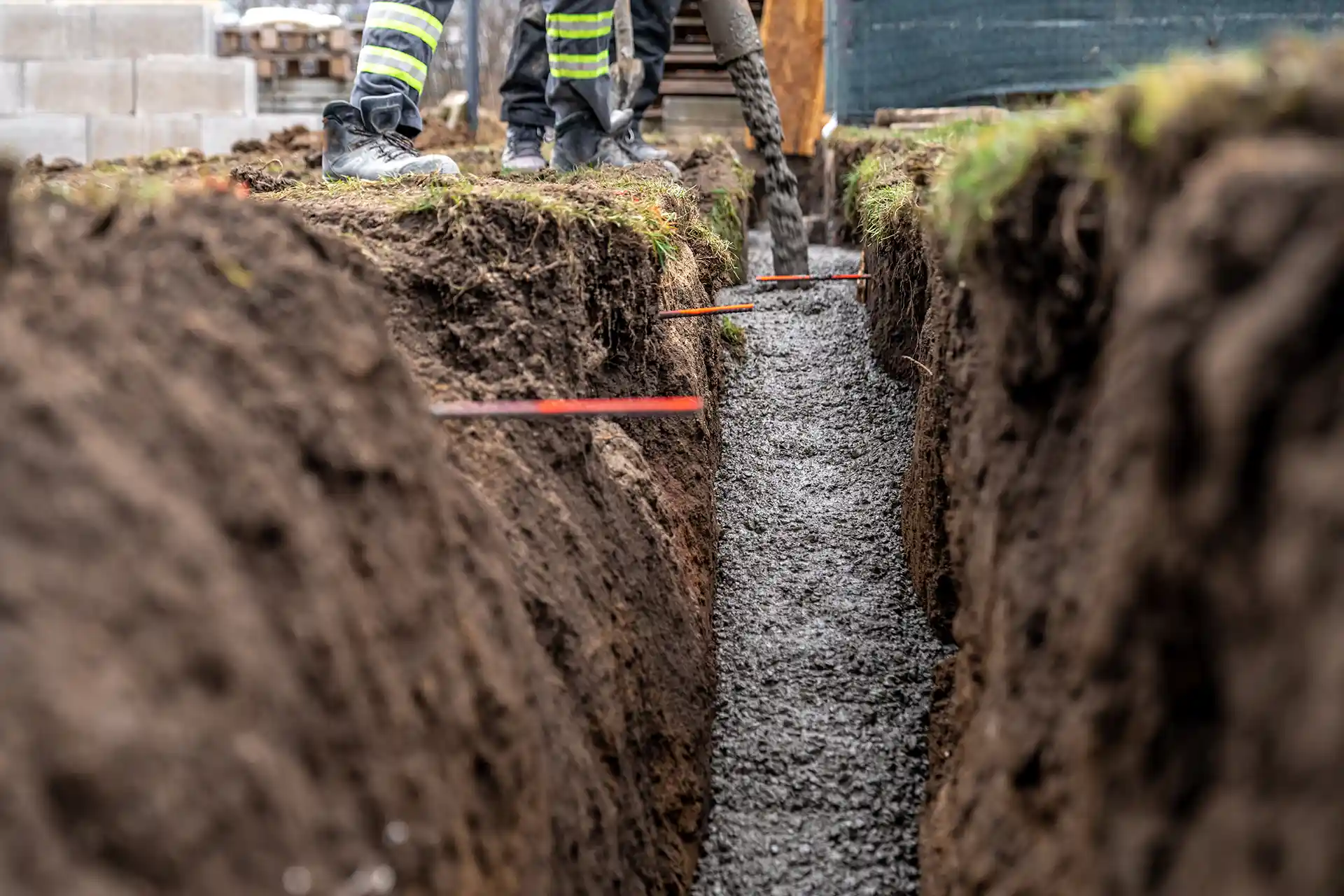 Concrete Foundations & Floor Slabs - Platinum Paving & Concrete Workers lay new concrete in a drainage ditch.
