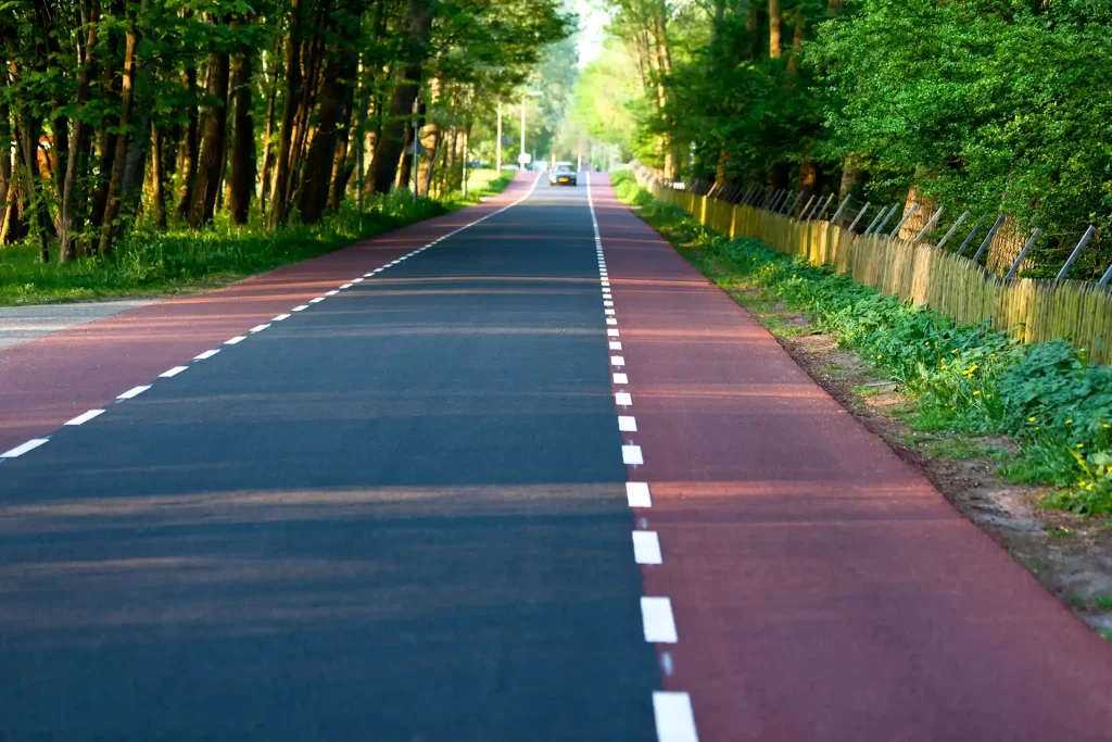Rural road with two sets of dashed white lines.