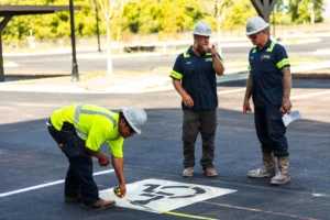 Contractor painting new ADA signs on a parking space.
