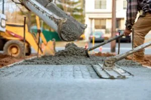 Concrete being poured from a truck onto a sidewalk