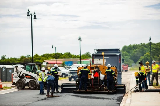 Platinum Paving workers pave a road with asphalt.