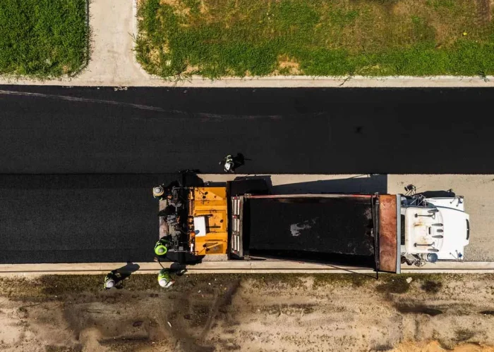 Platinum Paving lays fresh asphalt down on a road.