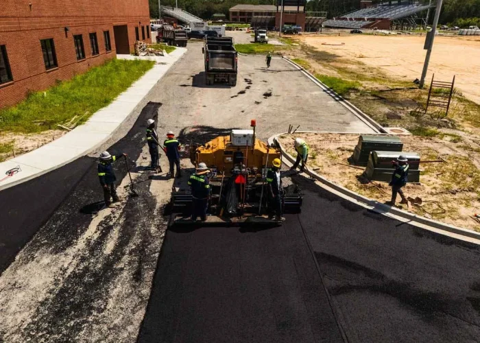 Platinum Paving working on laying fresh asphalt down on a school road.