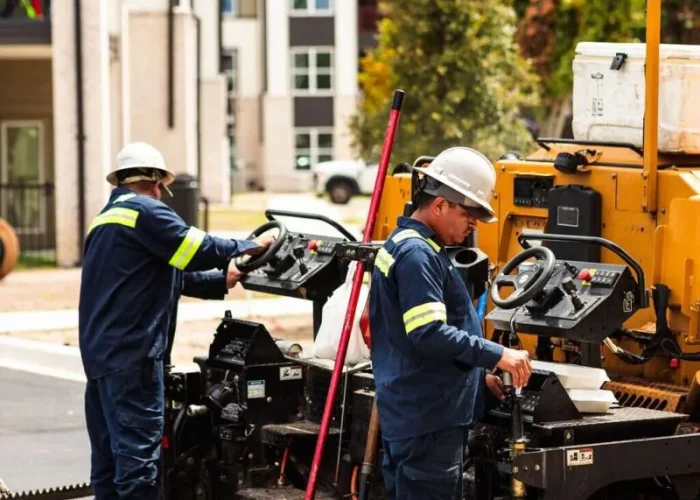 Platinum Paving workers operate an asphalt paving machine.