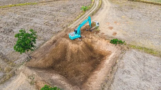 A teal excavator working on a construction site.